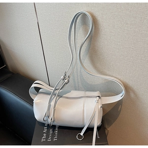 Detail of light blue cylinder bag with long tassel zippers on a design book