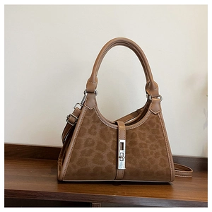 Detail of leopard print bucket bag with silver metal buckle on wood surface