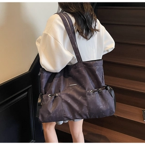 Détail d'un grand sac cabas violet marbré avec poches avant et boucles en métal élégantes