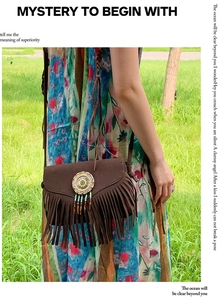 Detail of brown bohemian suede crossbody bag featuring colorful beads and long fringes
