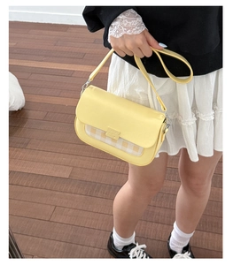 Détail d'un sac bandoulière jaune vif avec un rabat à carreaux et une finition en cuir