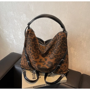 Detail of leopard print canvas multi-way bag with leather straps on a vintage magazine