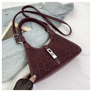 Detail of burgundy leopard print bucket bag with silver twist lock and leather textures