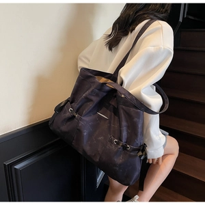 Détail du grand sac cabas marbré violet avec barre en métal porté à l'épaule