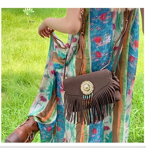 Close-up of bohemian brown suede fringe crossbody bag with handmade colorful beaded patterns