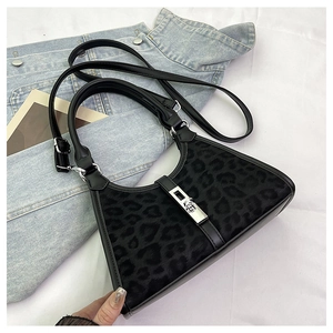 Detail of black bucket bag featuring faux leopard fur panel and silver metal twist lock clasp