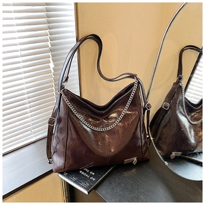 Detail of vintage oil wax leather texture and silver chain on brown tote bag