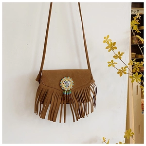 Close-up of brown suede tassel bag with Bohemian colorful beaded disc and V-cut flap