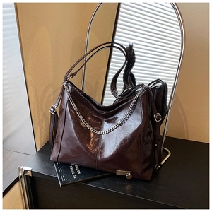Close-up of vintage burgundy crinkled leather tote with silver chain and heart charm