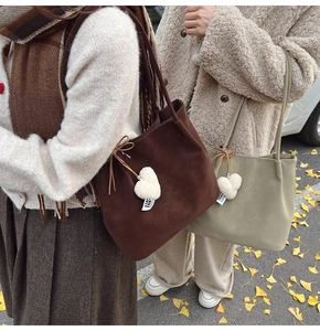 Outdoor street view of large suede tote bags in dark brown and sage green for autumn