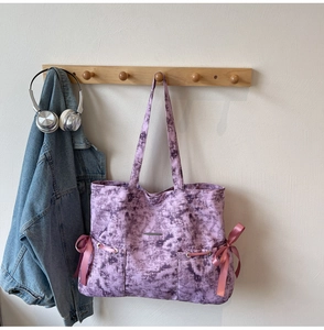 Détail du grand sac cabas violet tie-dye avec nœuds en ruban rose et accents en métal