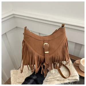 Close-up of brown suede crossbody bag with long fringe tassels and metal buckle detail
