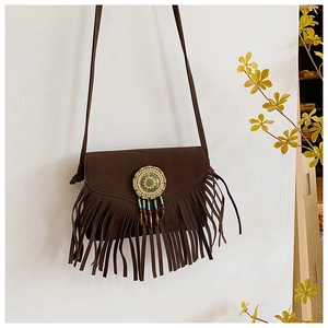 Detail of dark brown suede crossbody bag with long fringes and colorful beaded medallion
