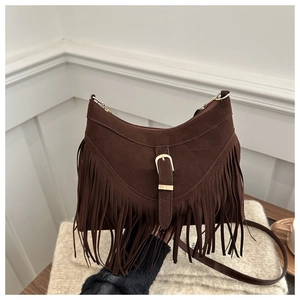 Close-up of vintage brown suede shoulder bag featuring long fringe tassels and gold buckle