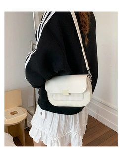 Détail du sac à bandoulière blanc crème avec panneaux texturés et boucle métallique