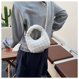 Rear view of white quilted bubble shoulder bag with chic textured fabric on a model