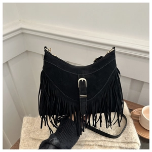 Close-up of black suede moon bag with long tassels and vintage golden metal buckle