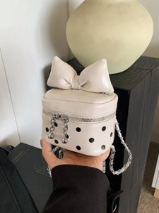 Cream mini crossbody bag with large bow, black polka dots and silver chain strap