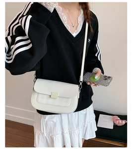 Détail du sac bandoulière blanc en similicuir avec motif à carreaux et boucle verte
