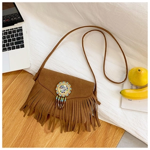 Detail of bohemian brown faux suede crossbody bag with long fringes and colorful beadwork