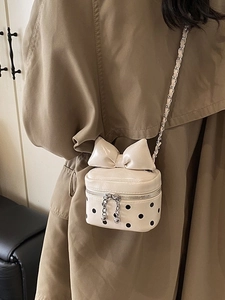 Chic mini white polka dot crossbody bag with large bow and metallic chain strap