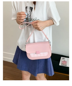 Détail d'un sac à bandoulière rose avec rabat à carreaux et sangle ajustable sur modèle