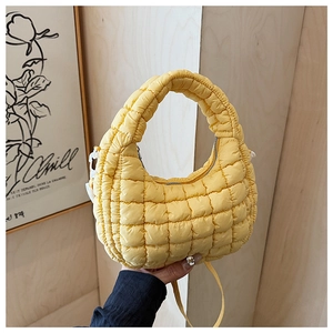 Detail view of yellow quilted half-moon handbag with premium soft padded texture