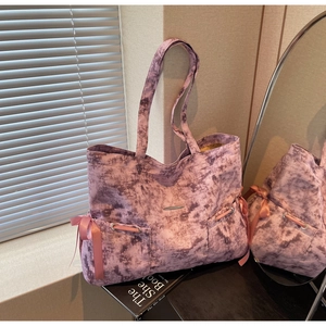 Détail du sac cabas en toile tie-dye violet avec poches à cordon en nœud de soie rose