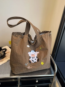 Braune Canvas-Tragetasche mit niedlicher Kuh-Stickerei und bunten Notenmustern