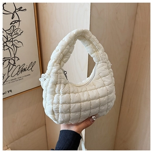 Detailed view of white quilted padded shoulder bag with soft textured pattern and zip closure