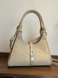 Beige leopard print bucket bag with silver twist lock and adjustable shoulder strap