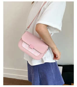 Sac bandoulière rose en similicuir avec détails à carreaux porté par un mannequin