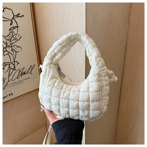Detailed close-up of white puffer tote bag featuring quilted square patterns and texture