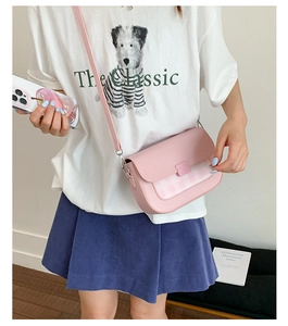 Sac bandoulière rose avec empiècement à carreaux porté pour montrer la taille et le style