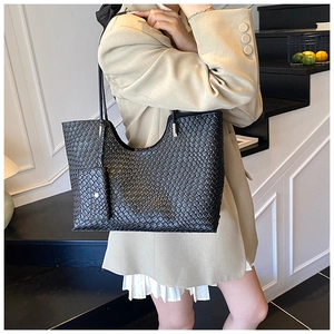 Détail du sac cabas tressé noir avec pochette assortie et design à texture premium