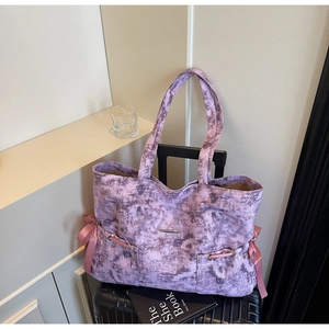 Détail du sac cabas marbré violet avec cordon en soie rose et plaque logo en métal