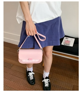 Détail du sac bandoulière rose avec bordure à carreaux porté en tenue d'été