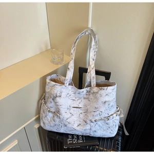 Vue détaillée du sac cabas marbre gris avec multiples poches sur une valise