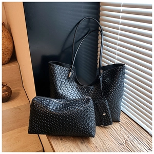 Détail d'un sac cabas noir tissé avec pochette assortie sur surface en bois