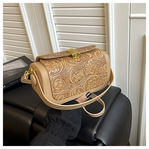 Detail of floral embossed vintage crossbody bag with elegant golden metallic buckle clasp
