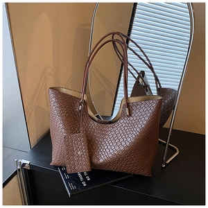 Détail du cabas marron tressé avec mini pochette assortie et texture en cuir PU