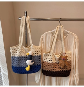 Detail of color-block crochet tote bags with plush charms on a minimalist metal hanger
