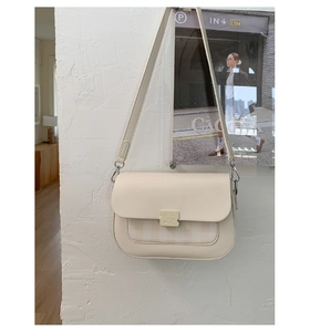 Détail du sac à bandoulière avec boucle en forme de fromage et empiècement en tissu à carreaux