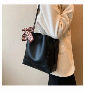 Large black leather tote bag with decorative scarf shown on shoulder for daily commute