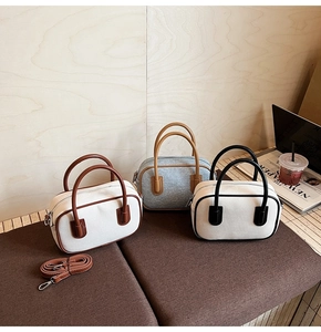 Retro Boston bowling bags in three colors displayed with detachable straps on a bench