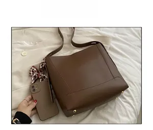 Deep brown leather bucket bag size comparison with smartphone and scarf detail