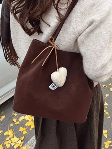 Vintage matte brown tote bag with plush heart pendant and bow detail for autumn outfits