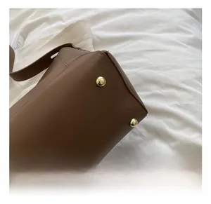 Close-up of brown leather bag base featuring gold-tone metal protective studs