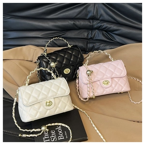 Détail de sacs à bandoulière matelassés avec chaîne dorée en noir, blanc et rose poudré