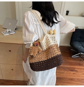 Detail of hand-crocheted gradient tote bag with grid texture and brown plush bear charm